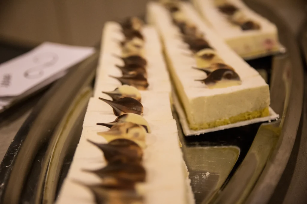 Lange witte taartstroken met chocoladeversiering op een zilveren schaal